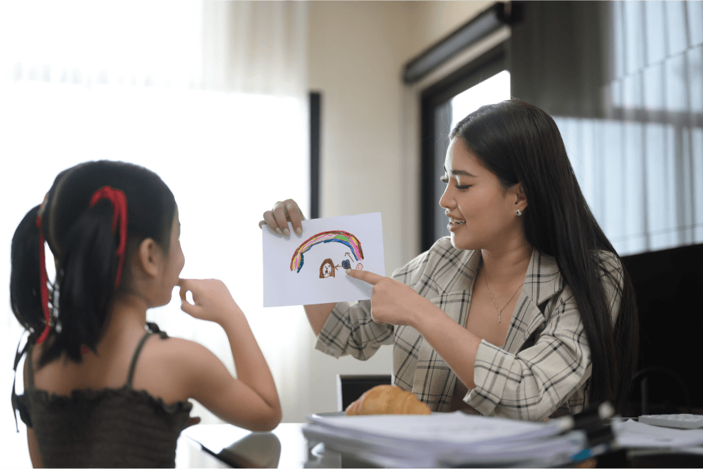 Mother showing a rainbow drawing to her child during bonding time at home.